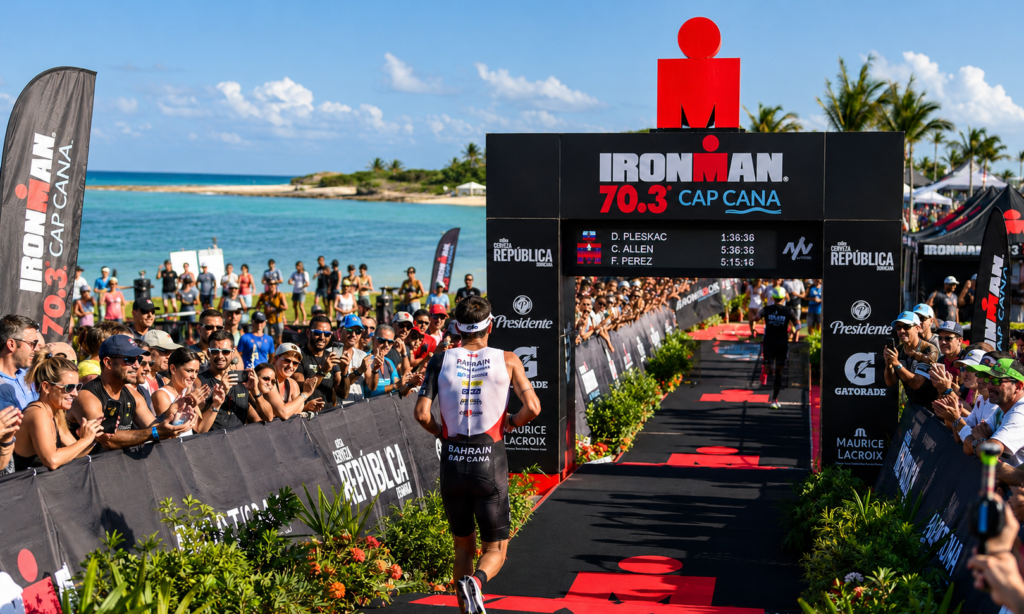 Athlete approaching the finish line at Ironman 70.3 Cap Cana as spectators cheer along the waterfront course.