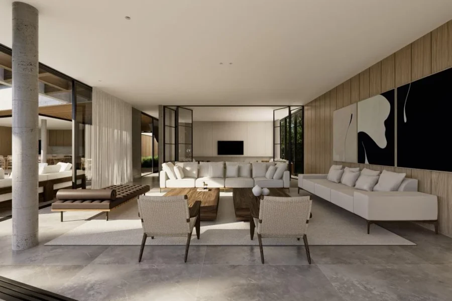 Open-concept living room with white sectional sofas, two woven armchairs, and wooden coffee tables in a sunlit modern home.